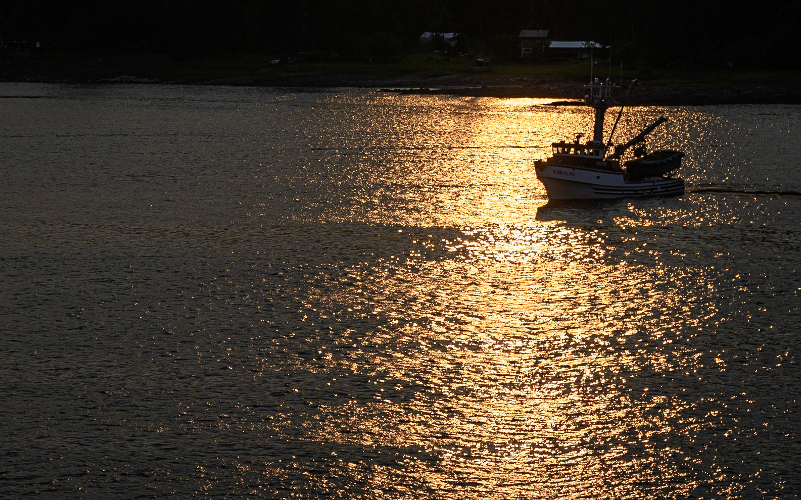 Fishing boat in reflection of setting sun. Petersburg Channel, Alaska