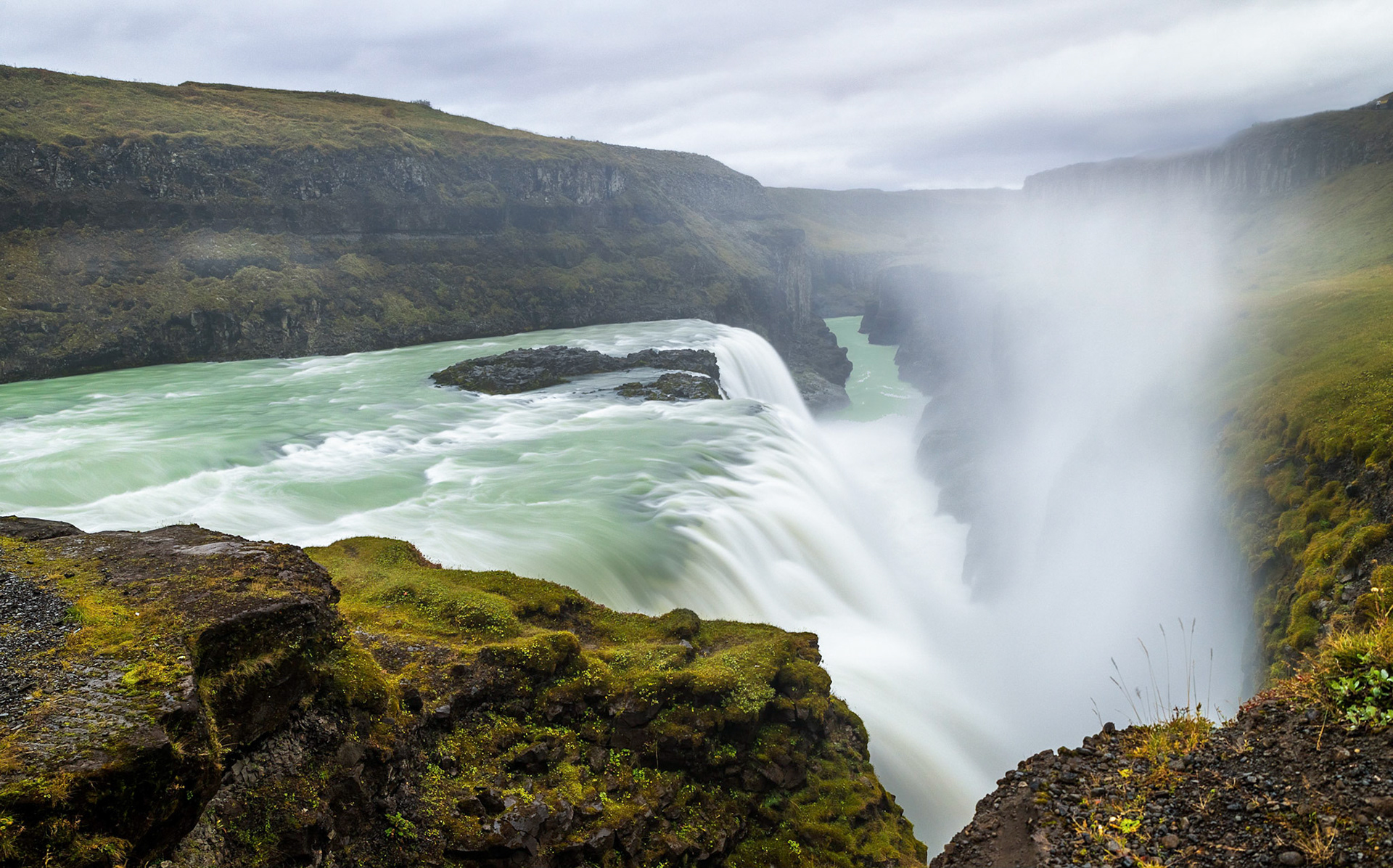 Seljalandfoss This waterfall has to be one of my favorites that I was able to photograph in Iceland! The fact that you are able to walk behind this waterfall made this beast truly special ! Before visiting this, I had imagined, climbing up the slippery path to the cavern behind the waterfall, and the sun would be rising through the mists. Unfortunately it was overcast and cloudy when we visited it. Still it was an experience to photograph this early morning in chilling winds soaked to the bones from the water mist. You get to a point where you just are going through the motions, sheer will making you cover all the possible compositions when your mind is screaming at you to get indoors into warmth and dry off. This was one of the easier shots of that morning, standing back from the waterfall away from the spray, admiring the magnificent waterfall in all its glory.