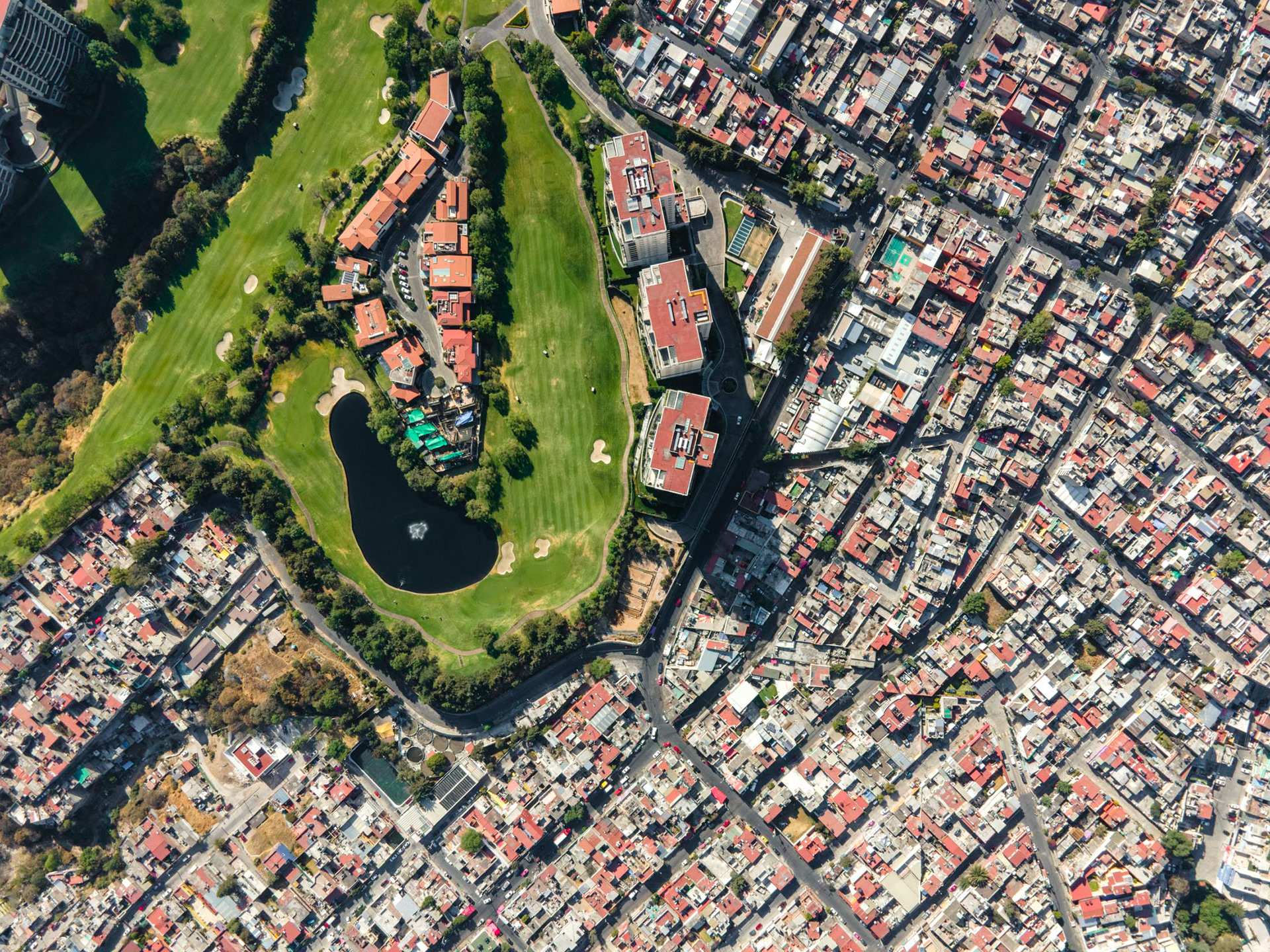golf course with rich homes next to slums in mexico city