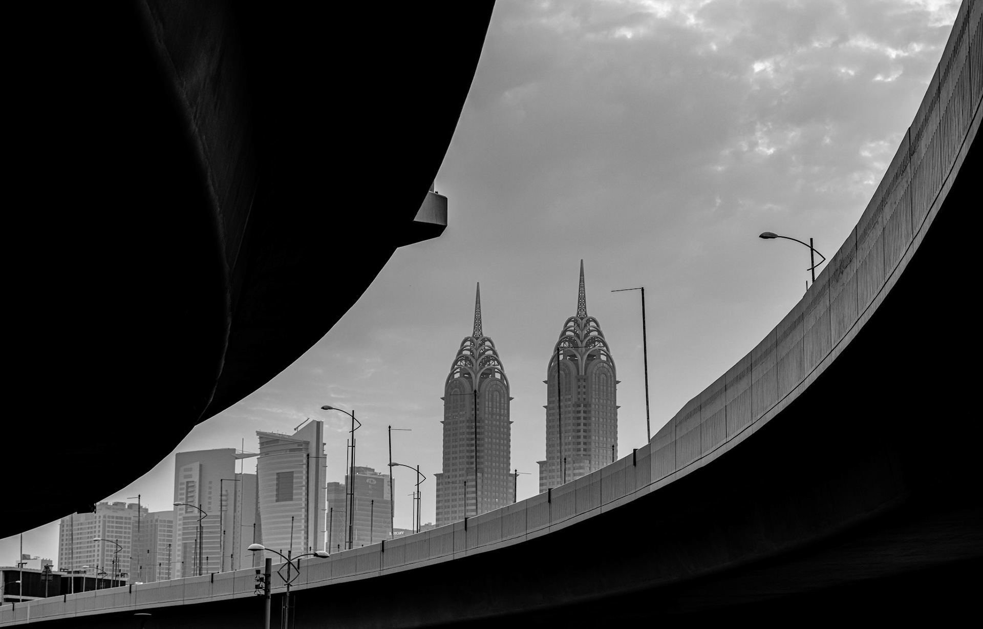 Black white detail pictures of a bridge in Dubai. Skyscraper in the background. Al Kazim Towers in the background.