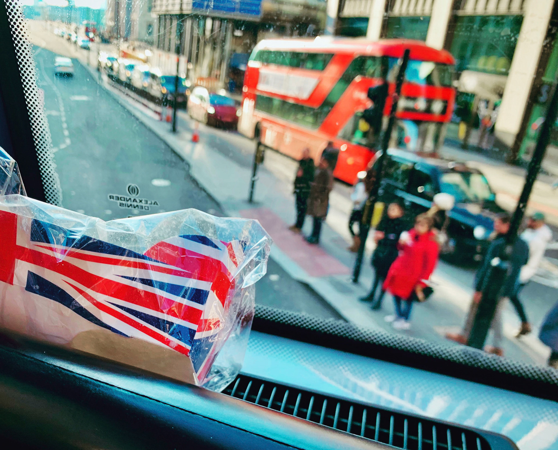 Blick durch Frontscheibe eines Doppeldeckerbusses, Pappschachtel mit Union Jack im Vordergrund, London, Vereinigtes Königreich