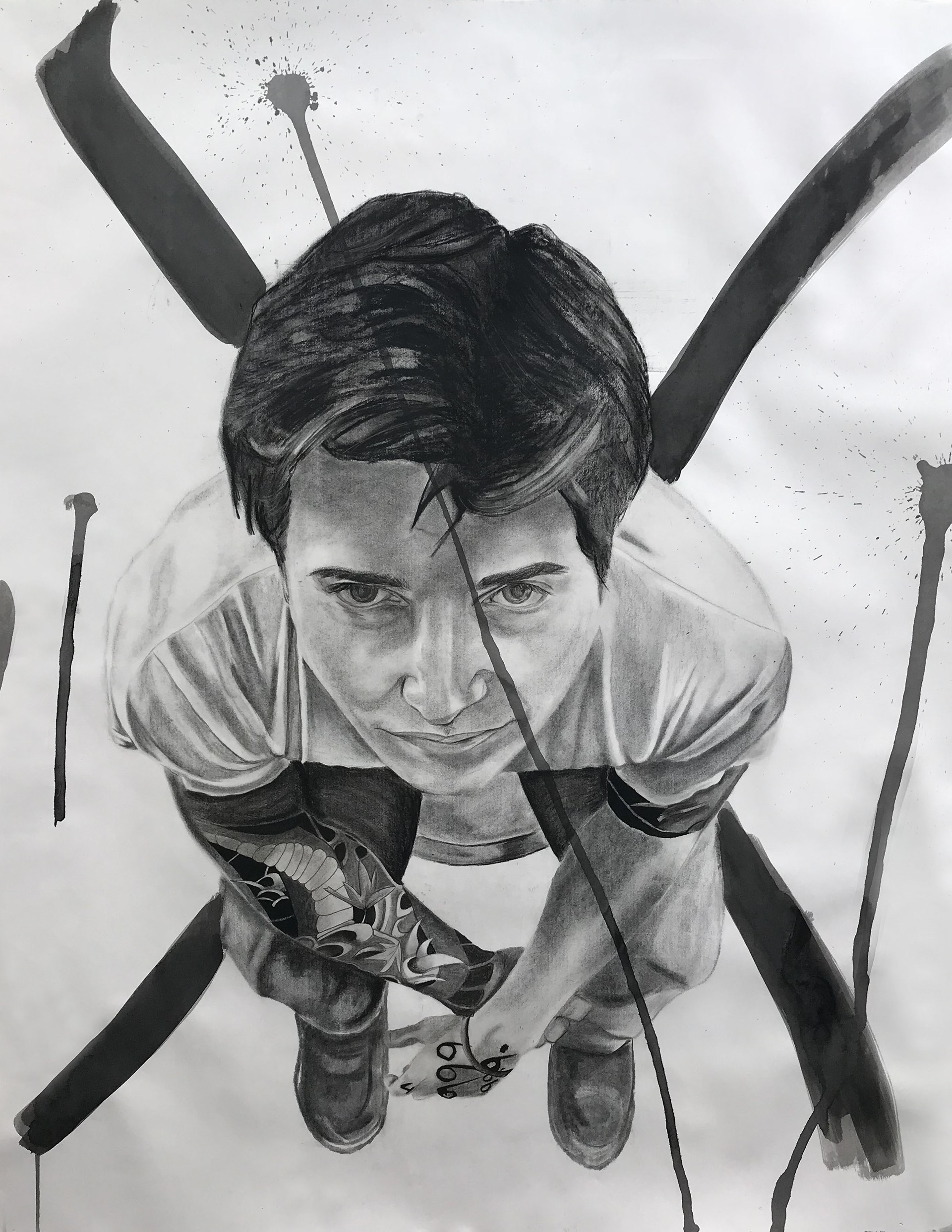 Large scale charcoal drawing of Aiden sitting, looking up, with ink crossing out his figure.