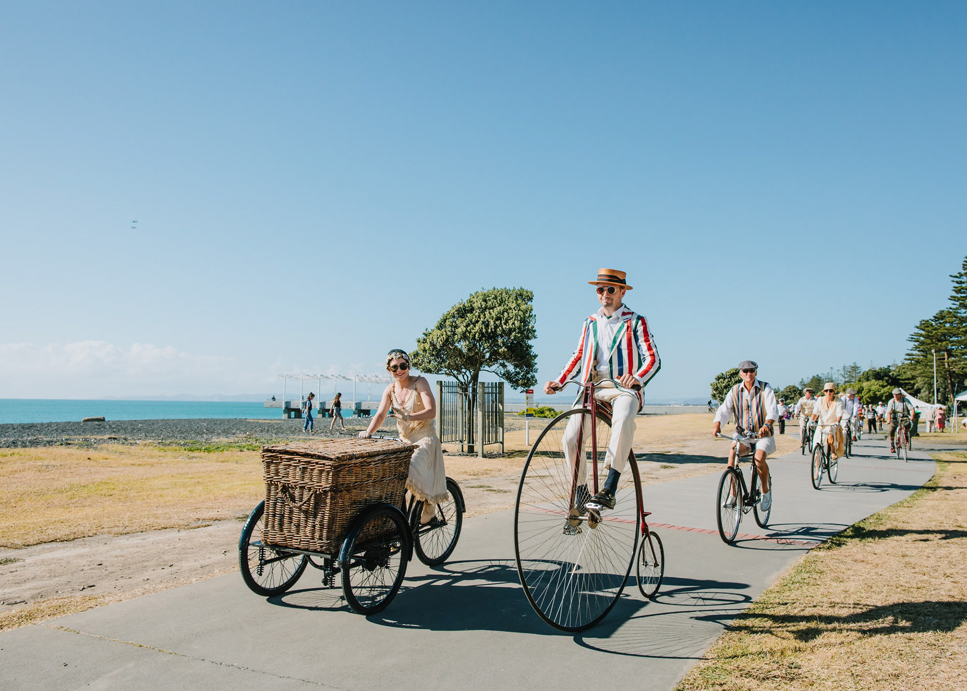 Cyclists on vintage bicycles riding along Napier's Marine Parade