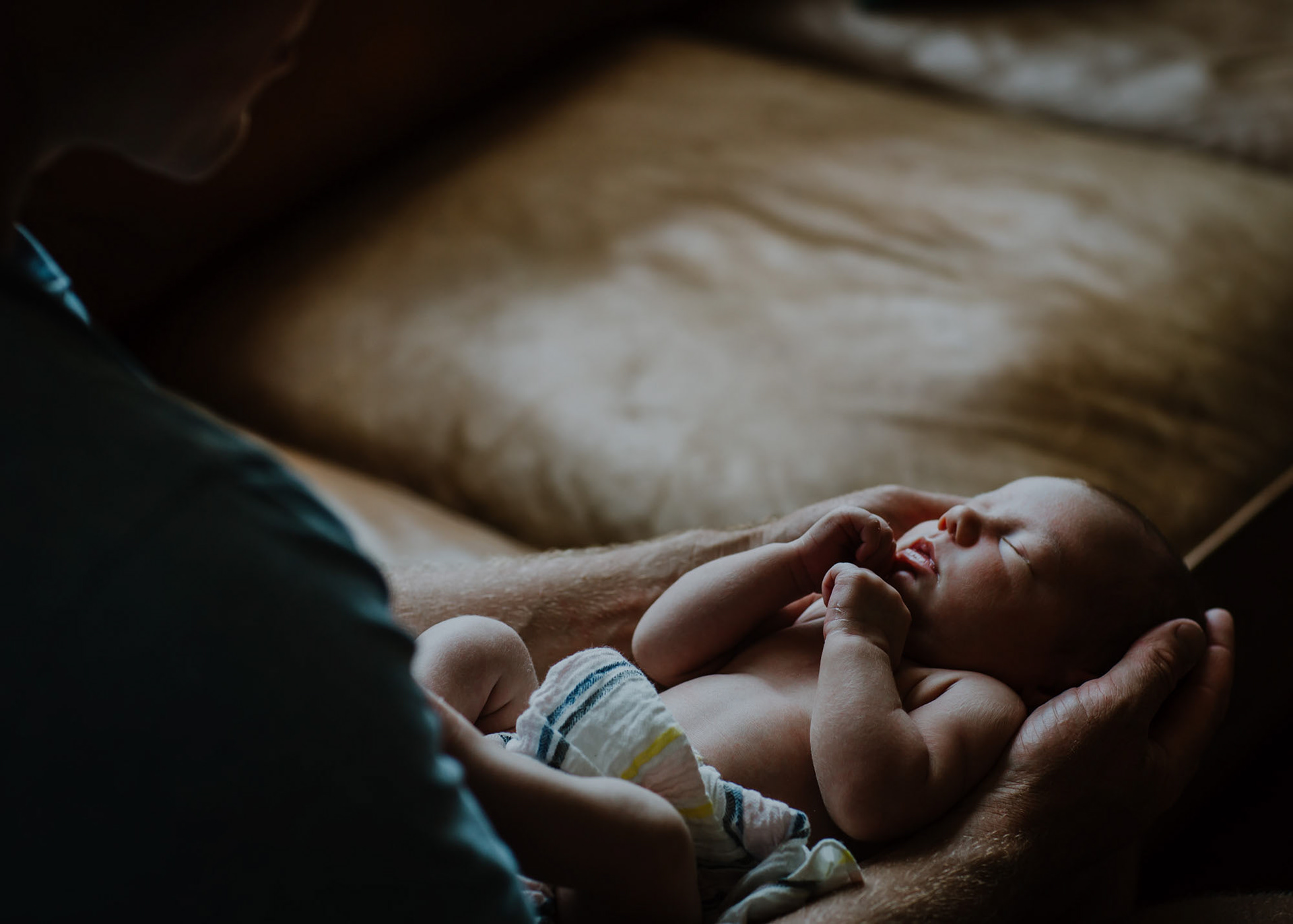 Newborn Adelaide asleep in her dad's arms
