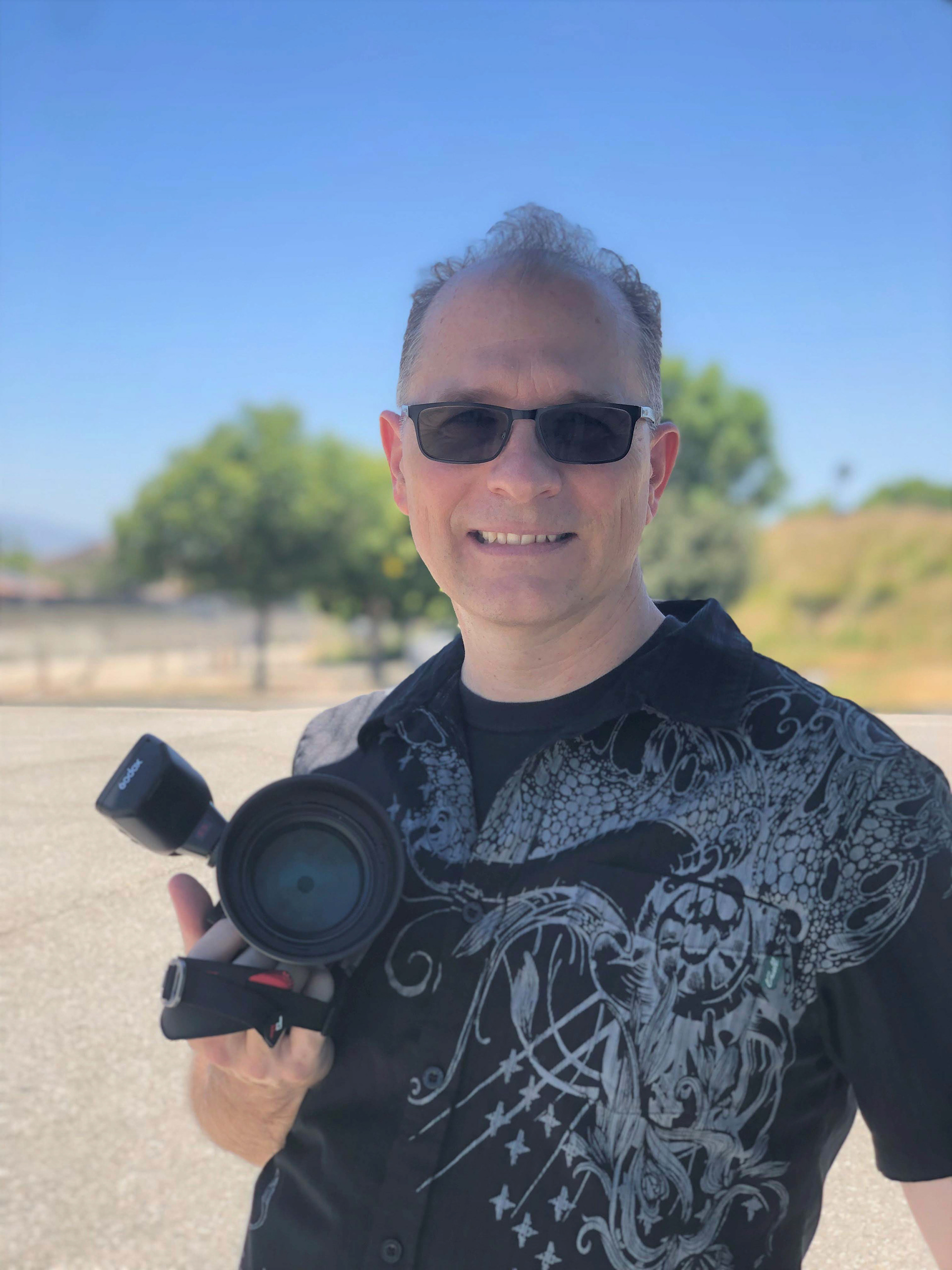 John Regent Cook holding his camera during a photo session Bryn Mawr Veterans Memorial Park