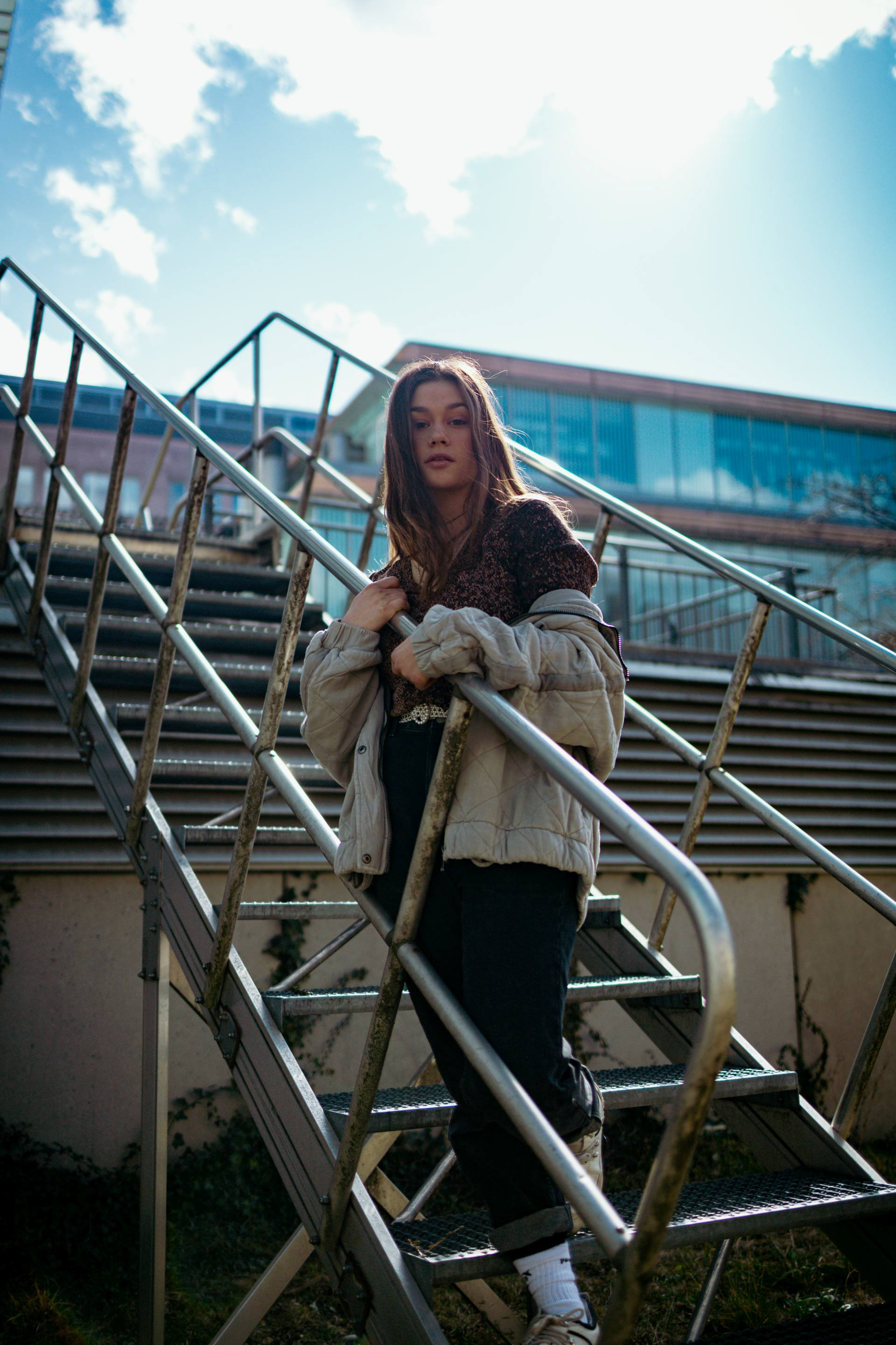 Zu sehen ist ein Porträt aufgenommen in München in Bayern. Im Porträt Foto ist eine junge Frau zu sehen, zum Teil auch Neon-Lichter, eine U-bahn, Fotoautomat und Rolltreppe. Die Aufnahmen an der Oberfläche wurden in München, nähe Rotkreuzplatz aufgenommen. Im Hintergrund der Porträts sind eine Schule und ein Krankenhaus zu sehen. Die Bilder sind für eine Portfolio Erweiterung geschossen worden.