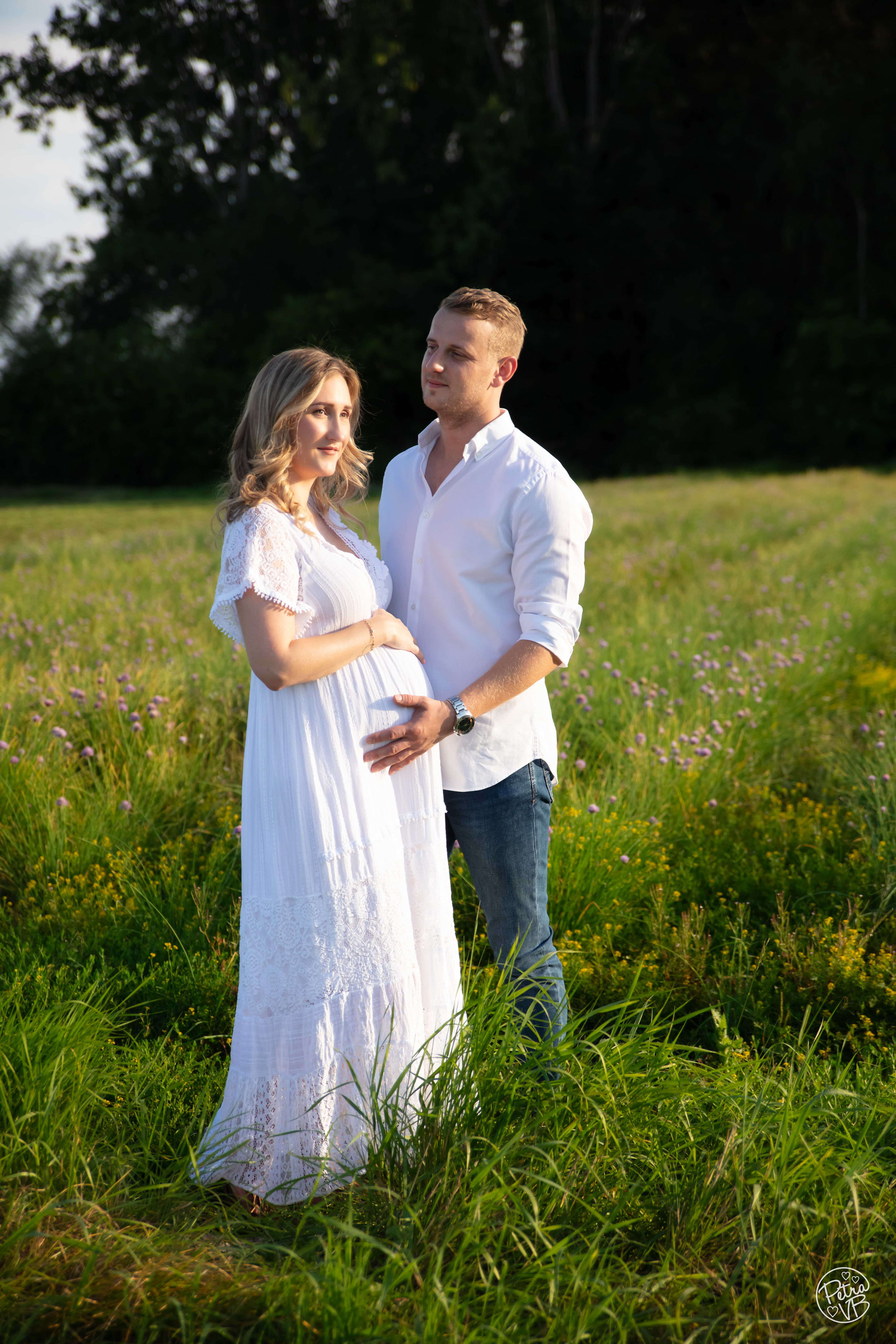 Koppel materniteit fotoshoot in een bloemenwei