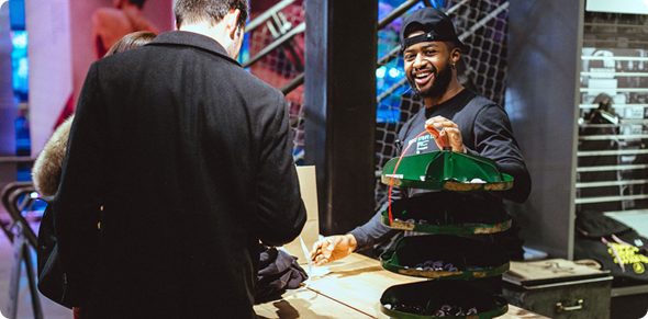 staff member interacting with attendees at the bodega counter