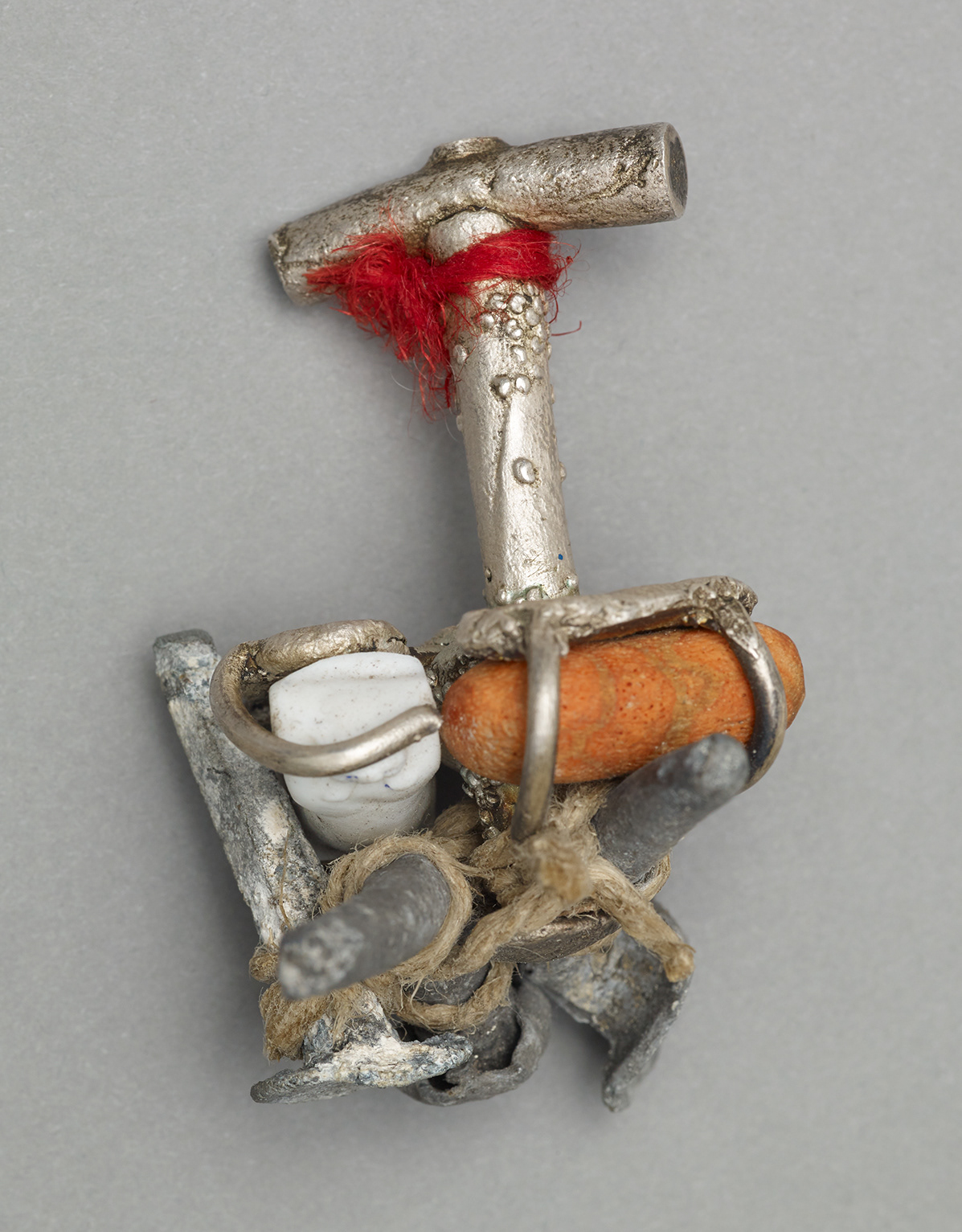 No.4 Item: Hand Object H 6cm W 5cm D 4cm Materials: Silver, found ceramic doll torso, coral, tourmalated quartz, roof nails from funeral home, thread Photo credit: Michael Pollard