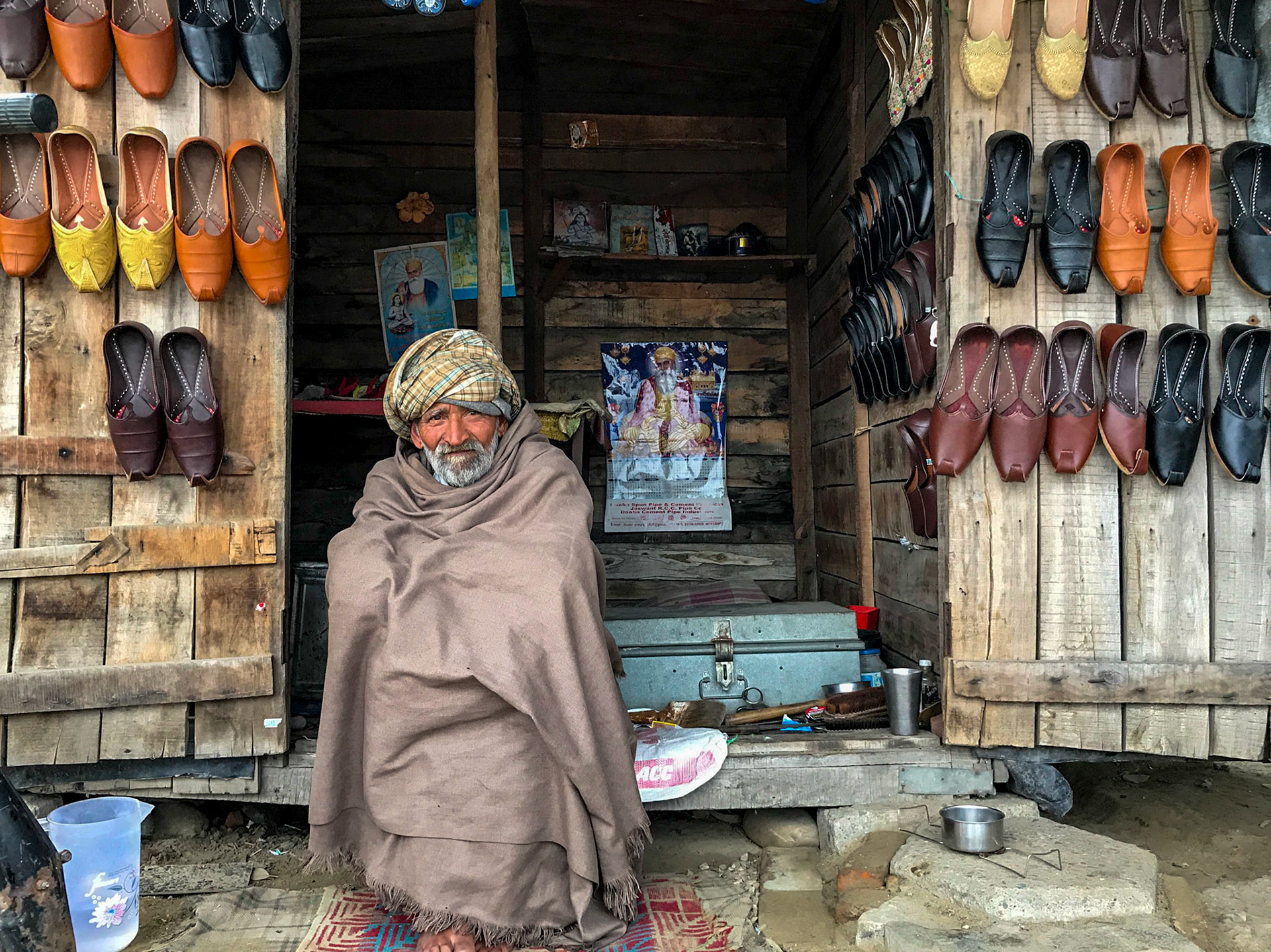 The warmth of a genuine smile can brighten the coldest, dreariest winter day.

I most enjoy street photography for the connection one can make in a jiffy, and elicit the most charming stories - of life, lives and livelihoods.

This man wasn’t always a cobbler, he was an artisan, but set up this shop to deliver his craft firsthand, to cut out the middleman - to earn more to marry off his daughter. 

I still smile when I see this photo and remember his story, and the cup of tea we shared sitting by the roadside on hyper-busy expressway