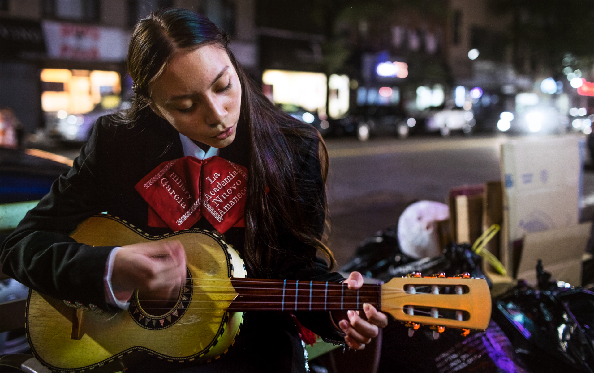 Hillary Garcia playing outside a bar in Queens as she and the other students wait to begin their performance. May 2017.