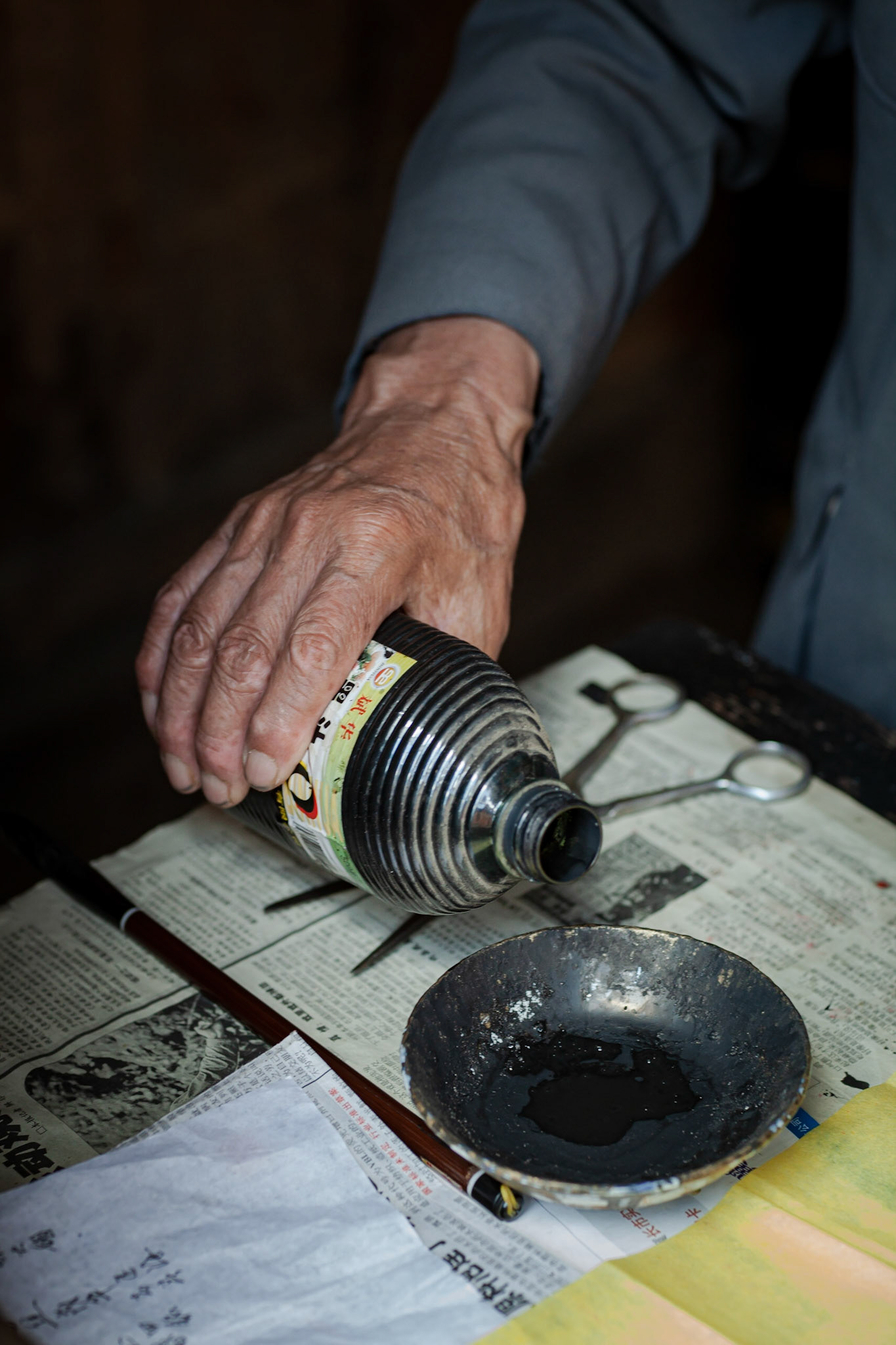 A Chinese Calligrapher making signs using traditional calligraphy in his shop in Shaxi, Yunnan Province, China.