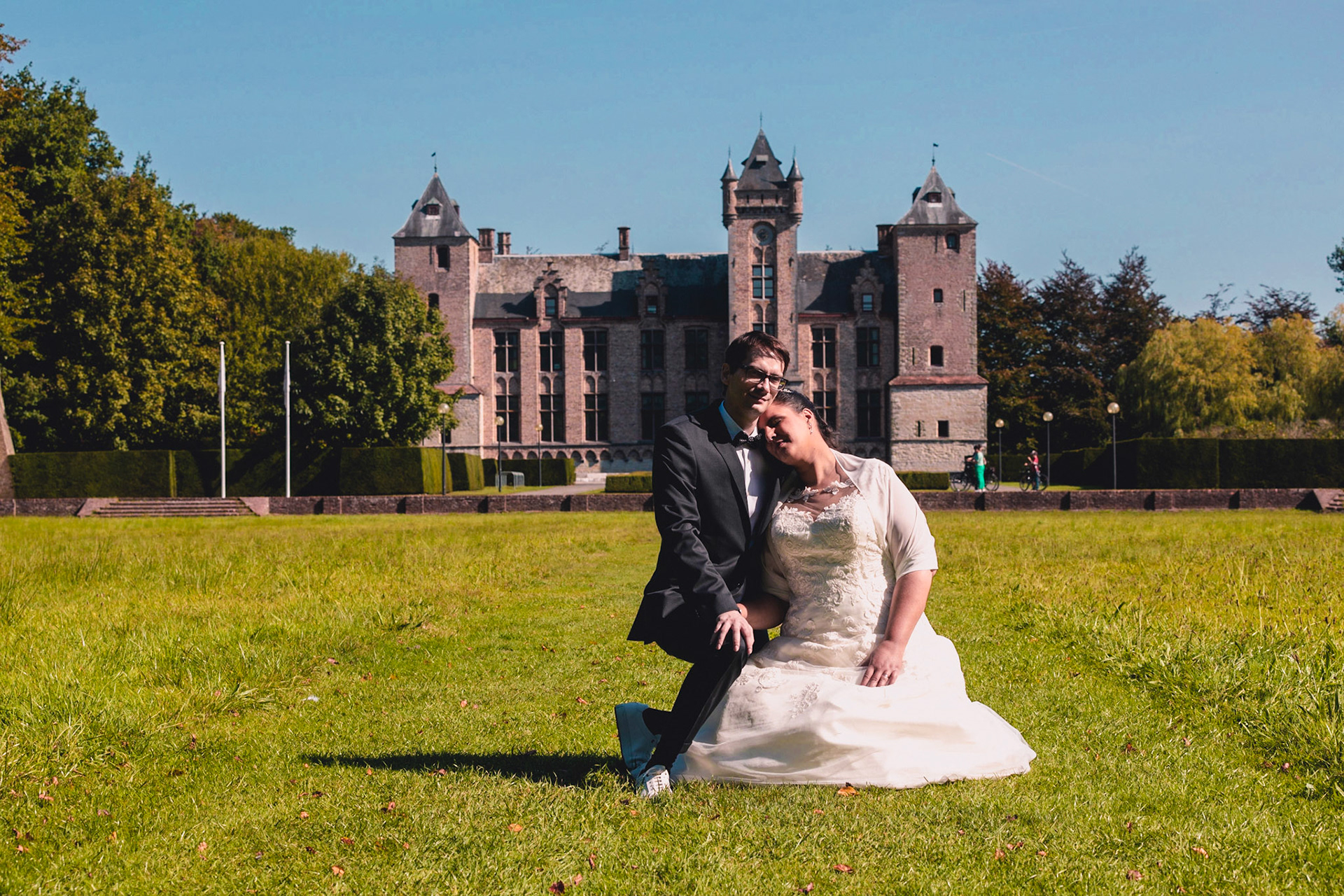 Bruidspaar in grasveld voor het kasteel van Tillegembos