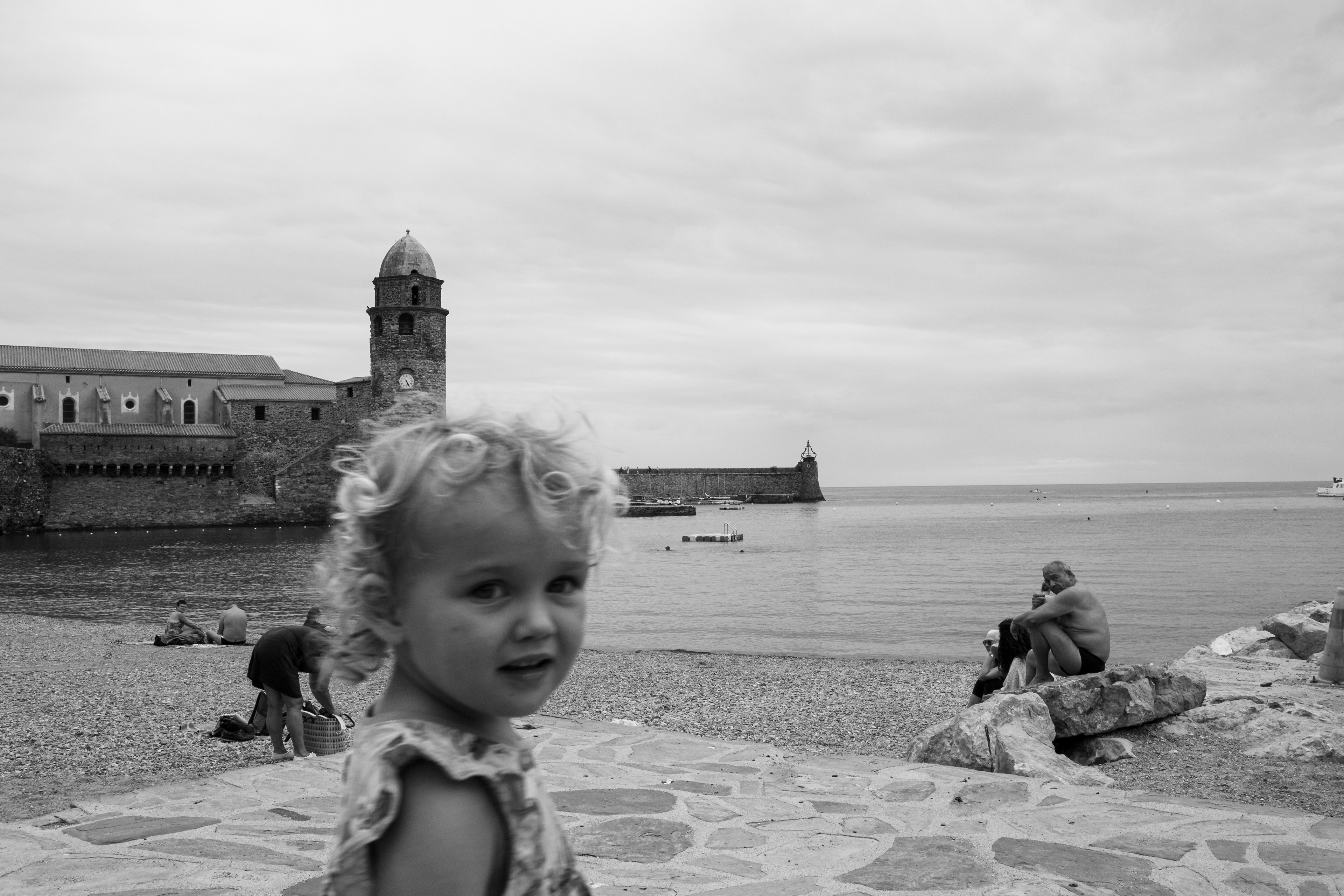 Child on a beach watching to the photographer