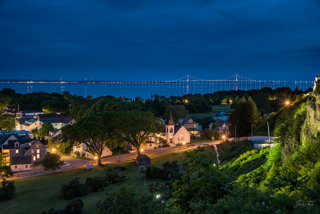 Mackinac Island at night, beautiful view from high above. Mackinac Bridge in a distance.