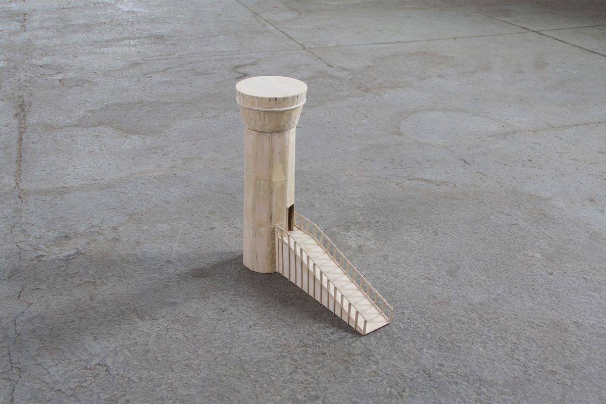 Balsa Wood model of a watchtower with an accessibility ramp sitting on the concrete floor.