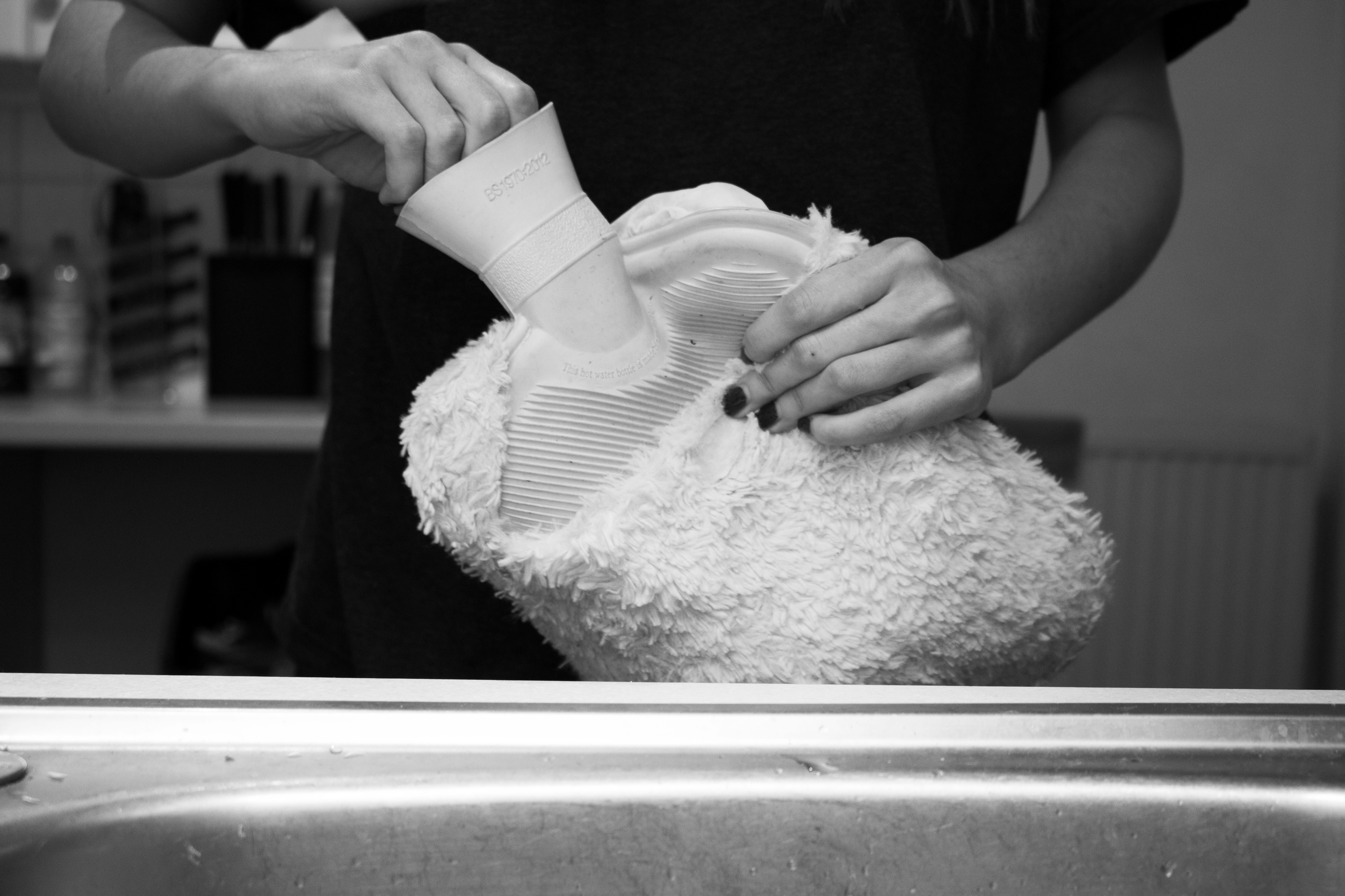 Hot water bottle lid being undone