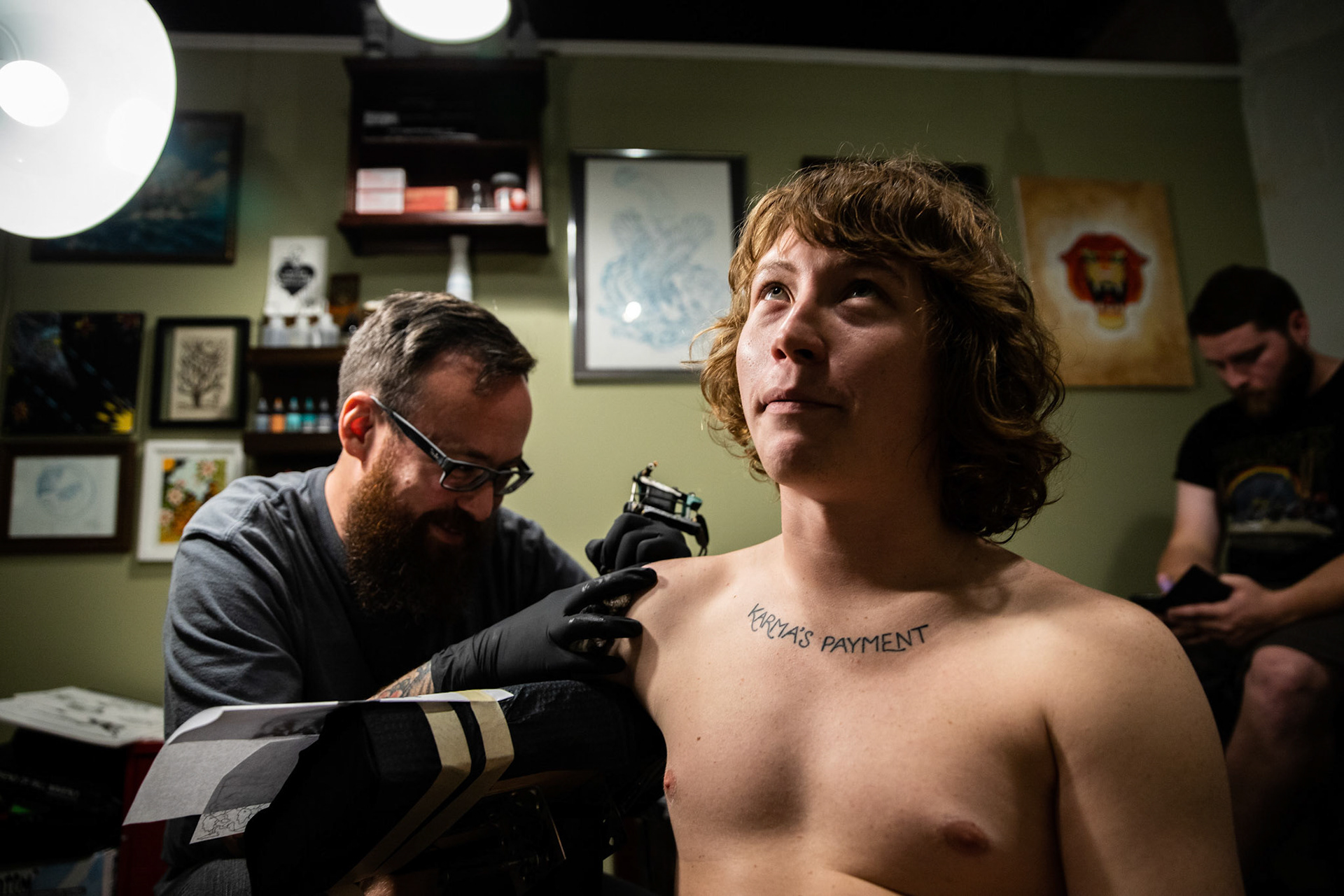 Hunter Anthony, center, is tattooed by John Snider, left, at Forever Tattoo in Asheville, North Carolina on September 26, 2018.