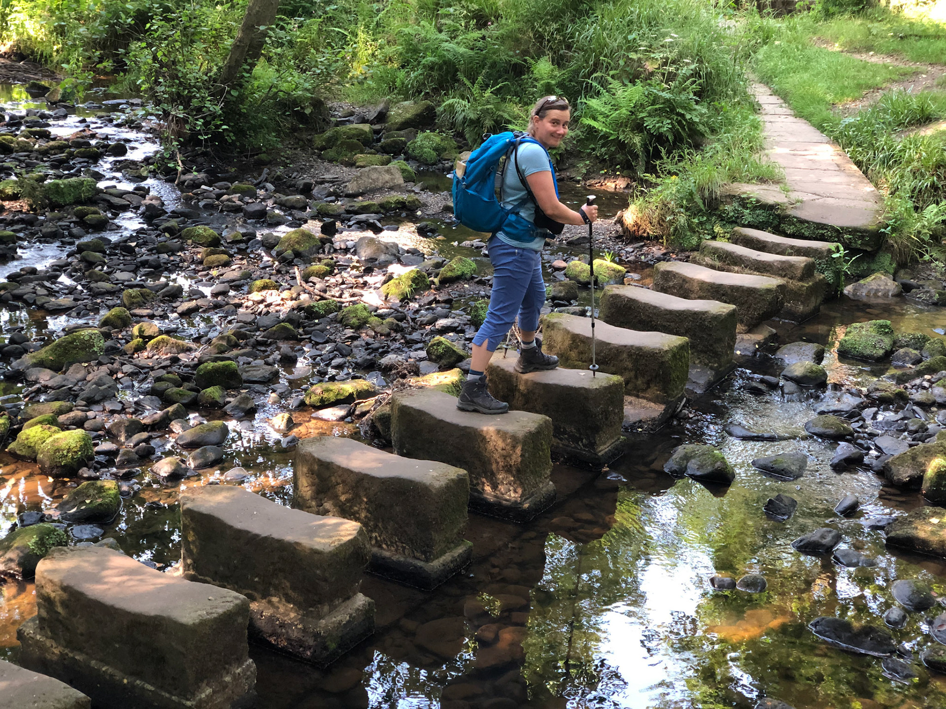 Sue crossing the stepping stones at Egton Bridge