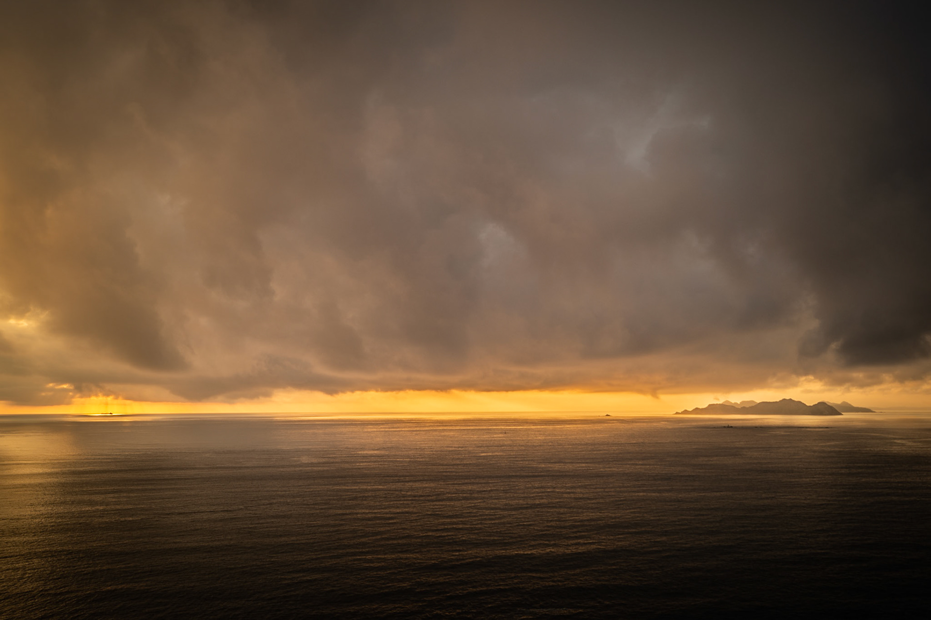 Espectacular puesta de sol en el horizonte desde Baiona, con la silueta de las Islas Cíes