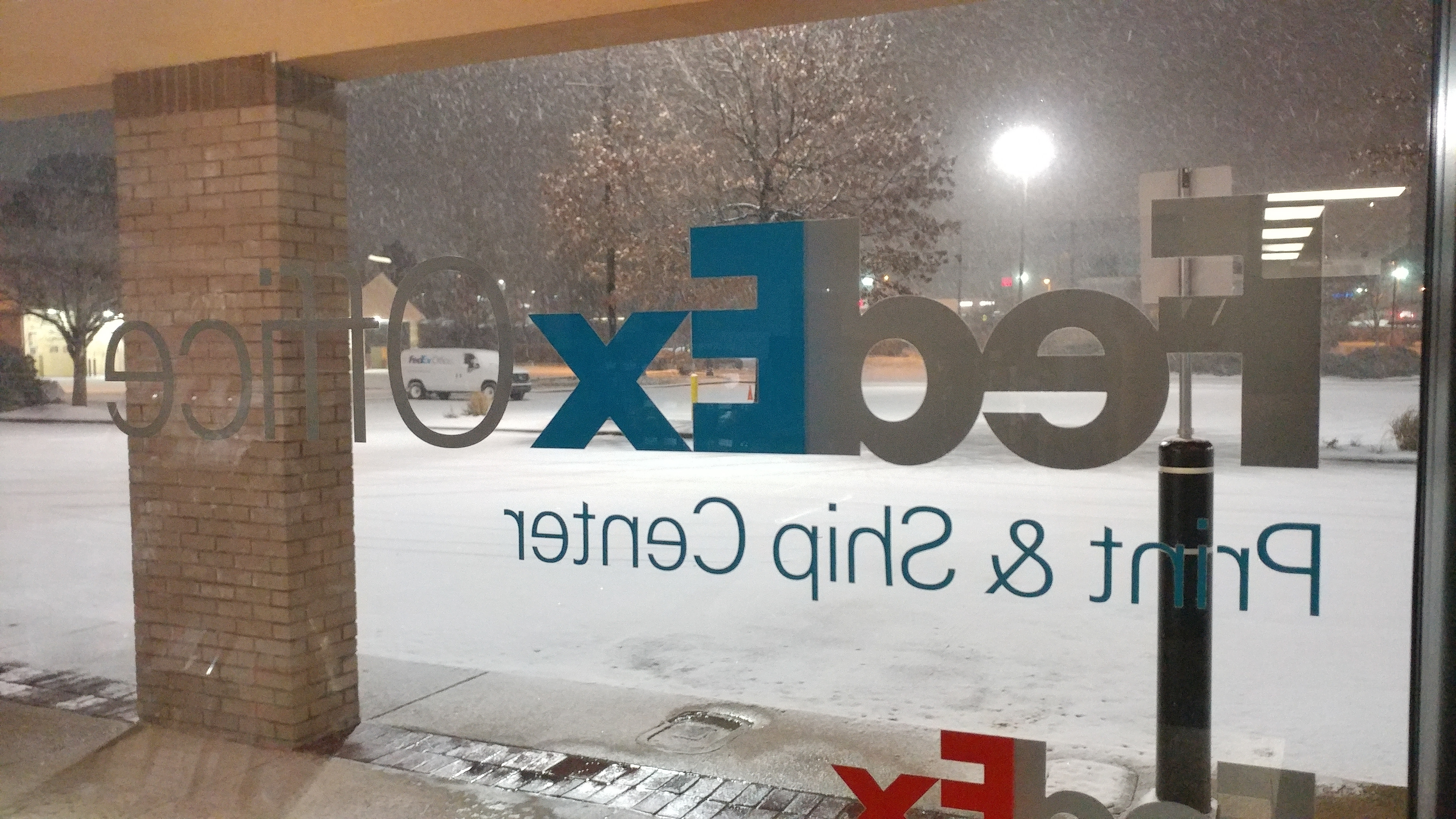 Looking through FedEx Office window at snow covered parking lot