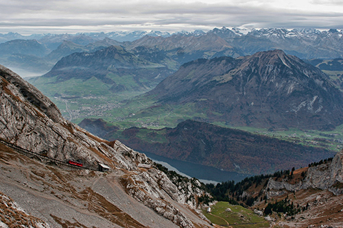 Red train travelling around Mt. Pilatus, Switzerland; UA-92916515-1