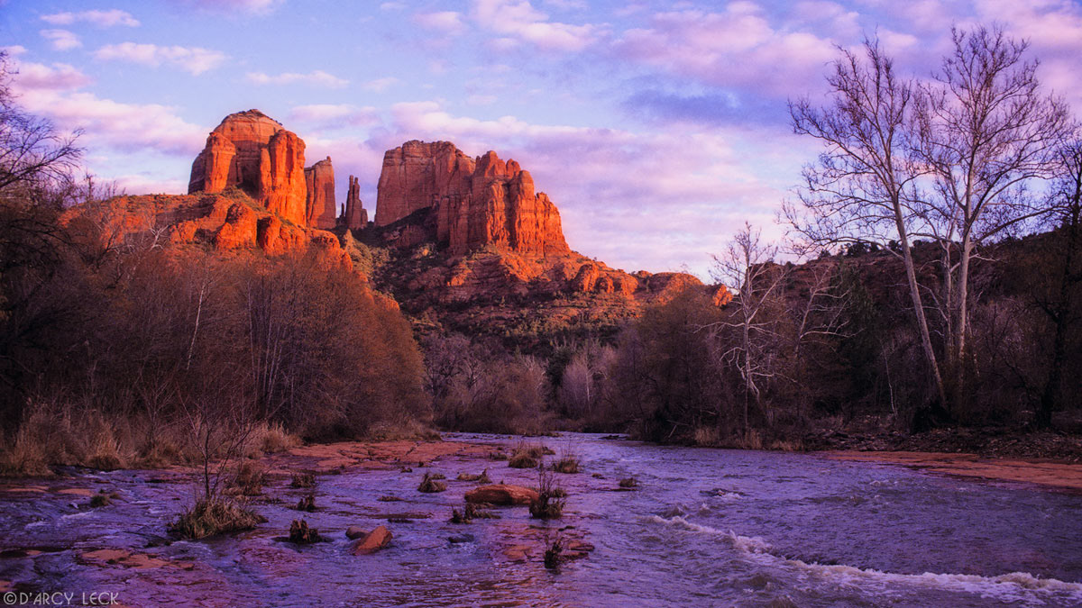 Cathedral Rocks catch the last sunlight at sunset beyond Oak Creek in winter, Arizona