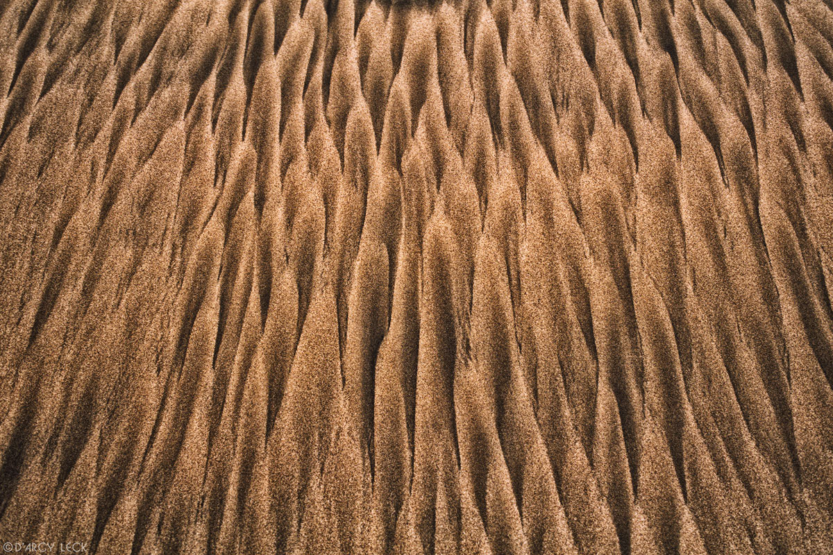 Black and brown sand streaks on beach