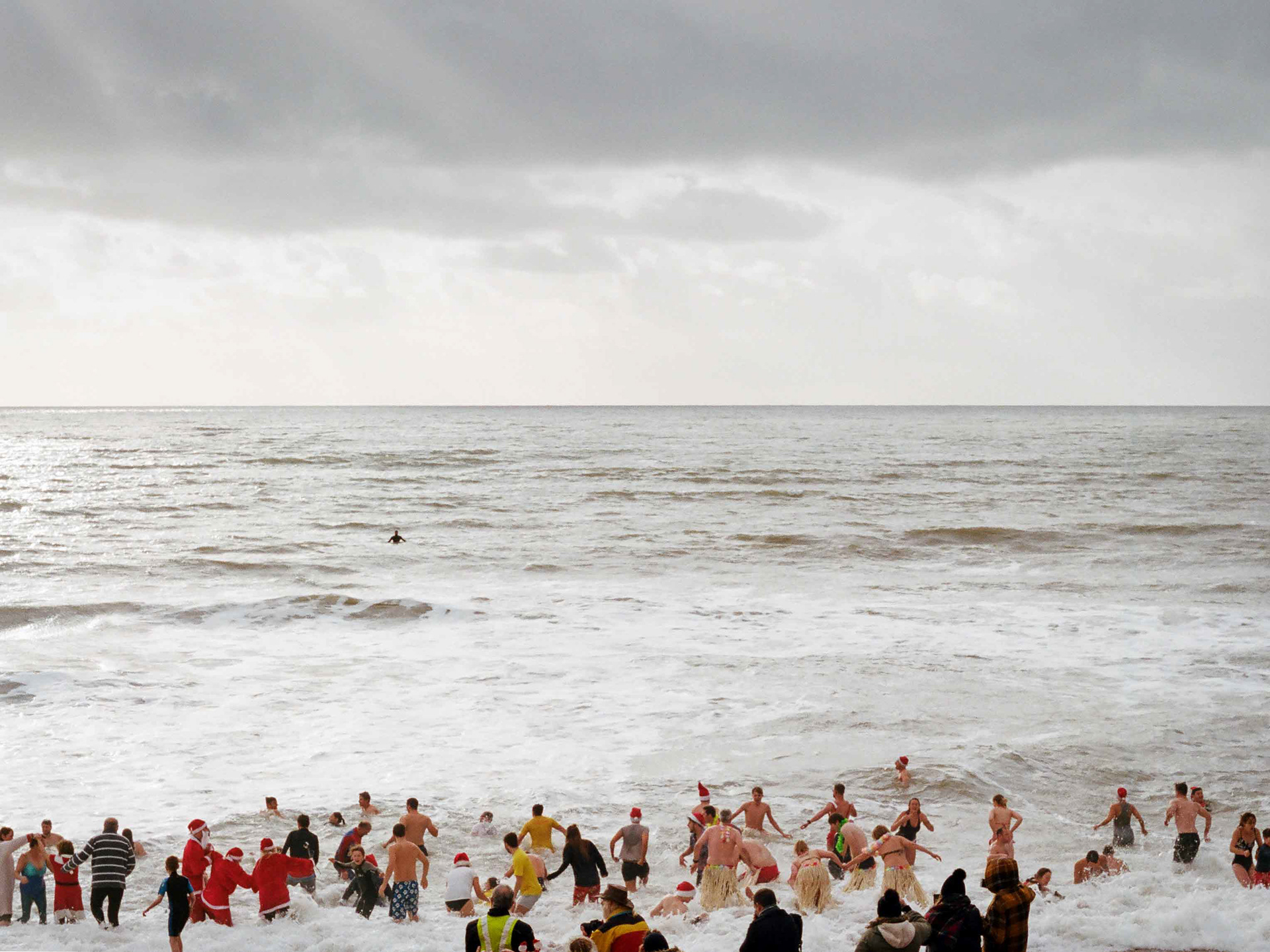 A landscape looking out to the Boxing Day swim at Ventnor, Isle of Wight. A medium format photograph taken by Bristol based photographer Jake Hitchcock.